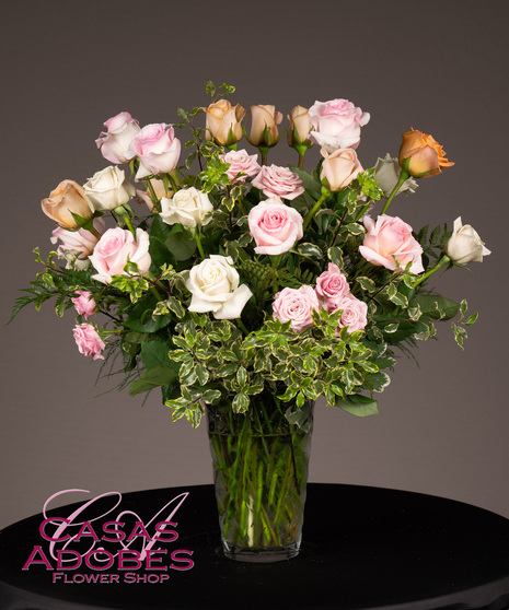 Vase filled with peach, pink and white roses