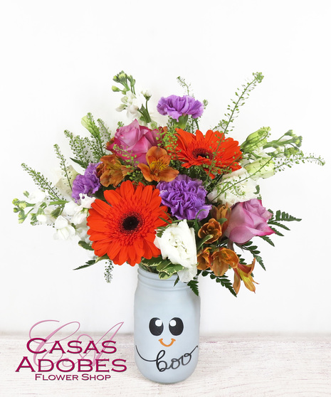 Halloween painted mason jar with orange gerbera daisies, purple carnations, white stock, penny cress, alstroemeria and lisianthus