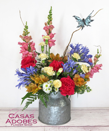 Galvanized tin with hot pink carnations, pink snapdragons, agapanthus, yellow mini carnations, and monte casino and butterfly on curly willow