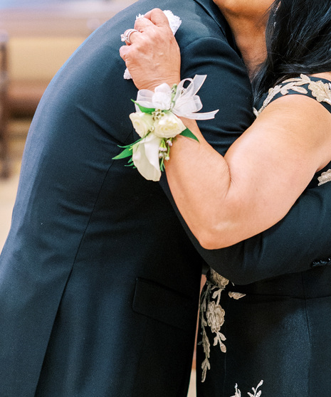 corsage comes with elegant white spray roses and a miniature calla lily with seasonal greenery and a coordinating bow.
