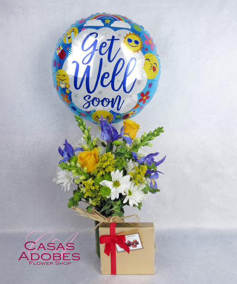 green mason jar vase with iris, yellow roses, and white daisies