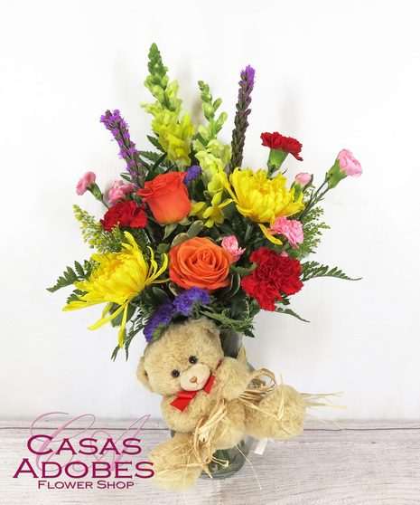 Spring Flowers in a vase with a plush teddy bear