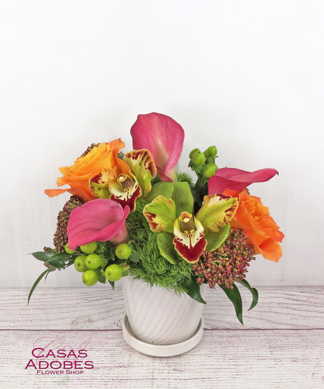 White ceramic pot with calla lilies, cymbidium orchids, dianthus, coffee berry and dark Queen Anne's lace