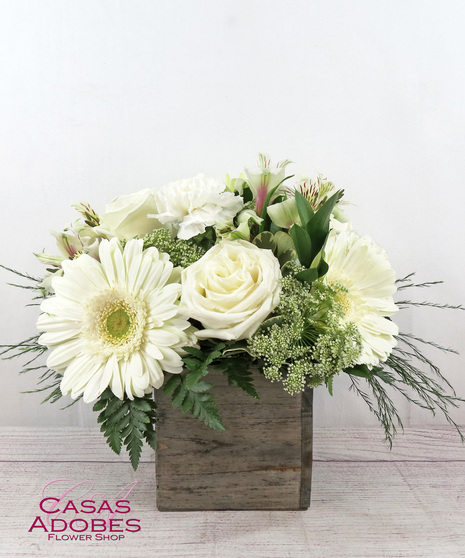 White gerbera daisies surrounded by white roses, white carnations, white alstroemeria, and Queen Anne's lace