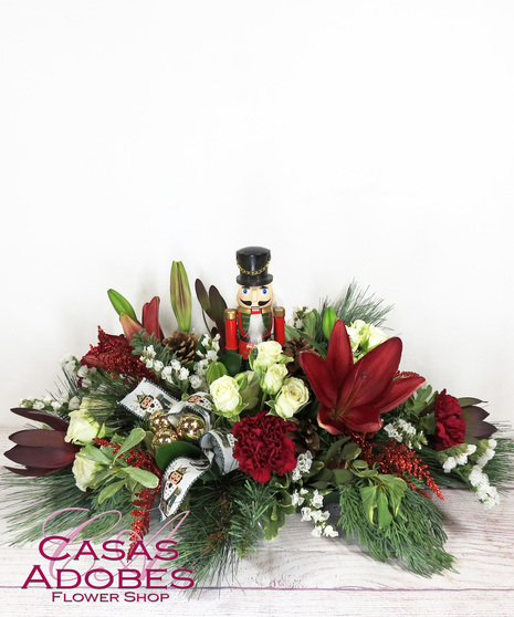 Centerpiece with Nutcracker with roses, lilies, statice, carnations, ribbon and ornaments