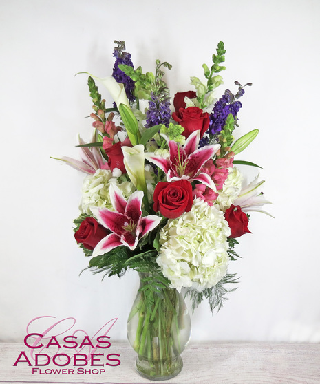 Vase of red roses, stargazer lilies, white hydrangea and snapdragons