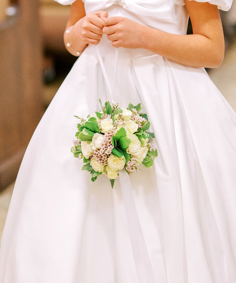omander ball is designed with elegant white spray roses, waxflower, seasonal greenery, and a coordinating ribbon.