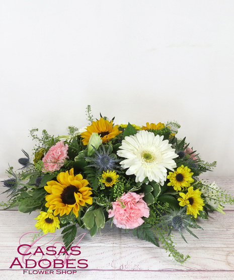 Low and lush centerpiece with sunflowers, snapdragons, gerbera daisies, carnations, lilies and solid aster